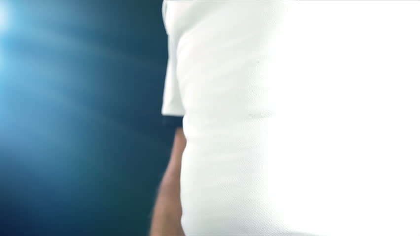 Footballer taking off his white T-shirt and change it with a blue one, slow motion
