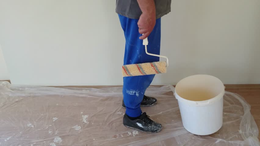 Man painting a wall white with paint brush