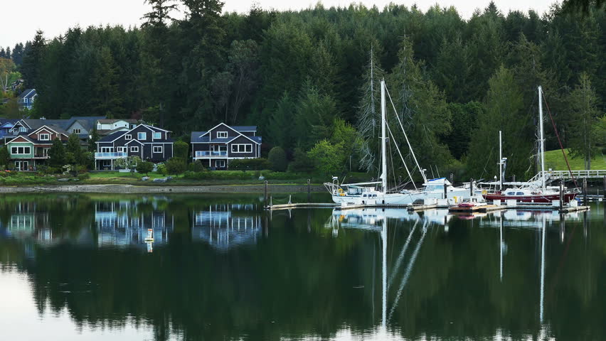 EAGLE HARBOR, BAINBRIDGE ISLAND, WASHINGTON - APRIL 2015: Beautiful calm morning on Eagle Harbor, Bainbridge Island, Washington with clear reflections in the peaceful water - Zoom out