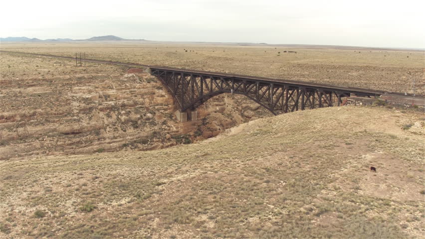 AERIAL: Flying around empty steel arch railroad bridge across the Canyon Diablo in the middle of the vast desert in Arizona