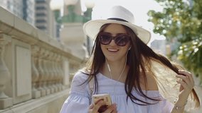 Woman in Hat and Sunglasses Makes a Video Call From Your Smartphone in Center of City. 