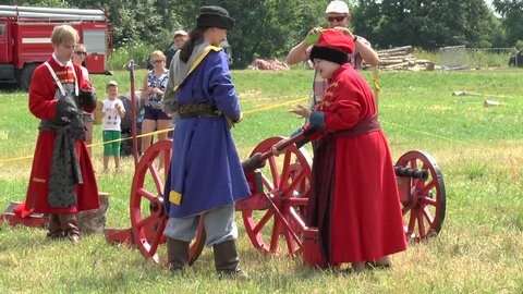 RUSSIA, DUSHONOVO - JULY 3, 2016: Unidentified people in medieval cloth reload and shot by cannon during history reenaction in Dushonovo village, Moscow region, Russia