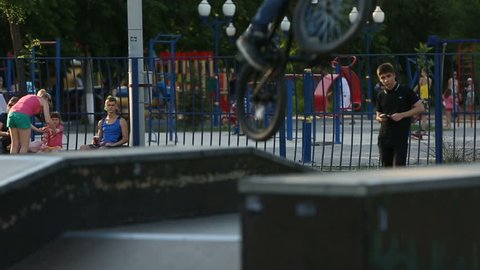BMX rider does various tricks while riding in skatepark