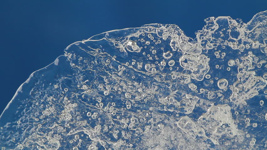 melting ice closeup on blue background. accelerated shoot