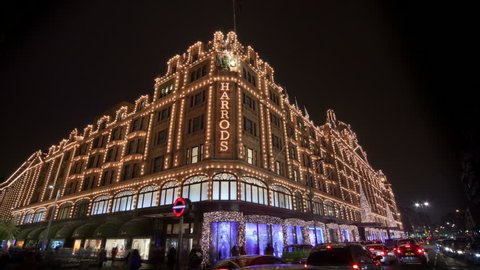 LONDON - CIRCA DECEMBER 2011 - Shoppers and traffic pass by the famous Harrods store in Knightsbridge which has Christmas lights and decorations.