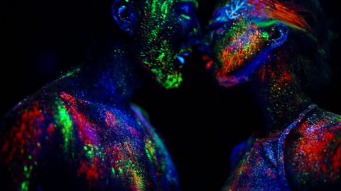 Passion couple in love painted fluorescent powder under ultraviolet light.