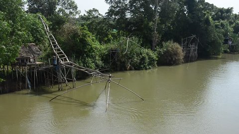 Fishermen use fishing lift and dip net machine fishing marine life in canal at Ban Pak Pra fishing village in Phatthalung southern provinces of Thailand