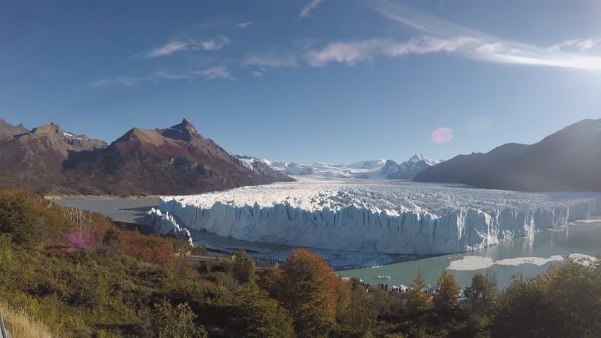 Smiling Happy Man With a Beard Shoots Himself and Glacier and the Picturesque Nature Around on a Clear Sunny Day