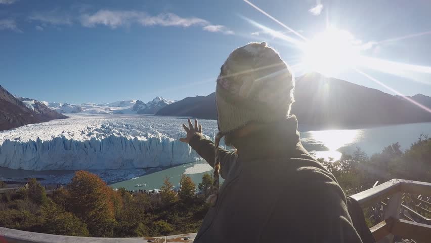 Smiling Happy Man With a Beard Shoots Himself and Glacier and the Picturesque Nature Around on a Clear Sunny Day
