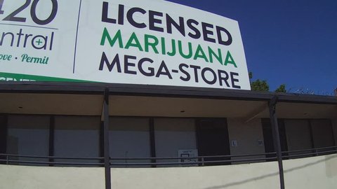 SANTA ANA, CA/USA: June 3, 2016- A close up pan shot of a billboard advertisement that promotes a marijuana mega store. 420 Central is a licensed and legal marijuana dispensary.