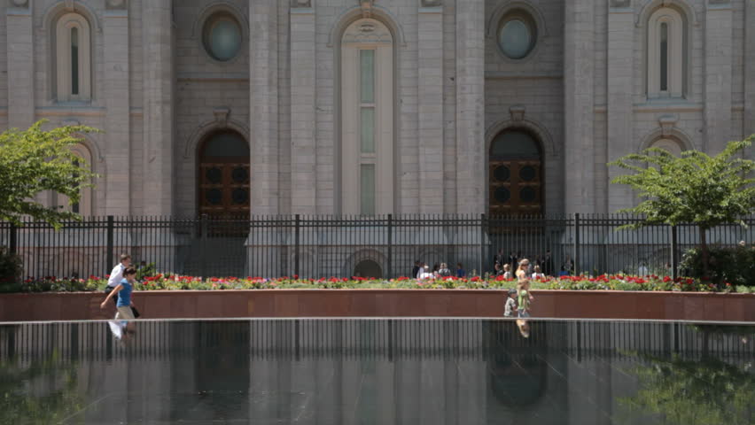 Historic and beautiful Temple Square and reflection pool with spectators and visitors walking in salt Lake City. Took forty years to build the temple late 1800.