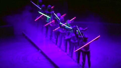 ST. PETERSBURG, RUSSIA - JANUARY 2, 2016: Brothers Zapashny circus, "UFO. Alien Planet Circus" show in Saint Petersburg. Aliens dance one after another with neon sticks in hands.