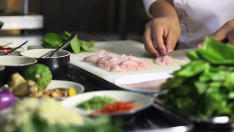 Close-up of chef hands cooking and preparing Asian food and sushi in restaurant kitchen. Rack focus