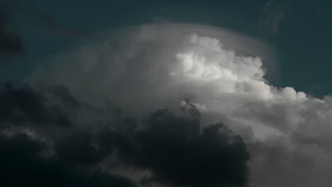 4K - Thunderstorm towering updraft cumulonimbus cloud with  dark cloud anvil and blue skies. 