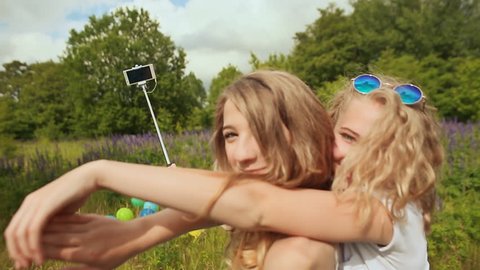 Two girls doing selfi with selfi stick
