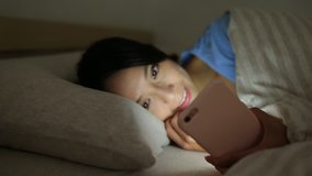Woman using mobile phone before sleep at night