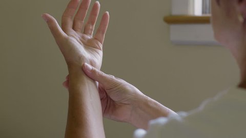 Woman massaging her arthritic hand and wrist