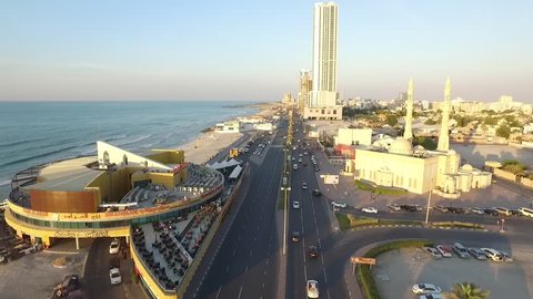 AJMAN, UAE - CIRCA NOVEMBER 2015: Cityscape of Ajman with modern buildings aerial top view and traffic on road. Coastline with beach and gulf. Sunset time. Ajman is the capital of the emirate of Ajman