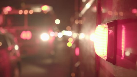 fire department trucks with flashing siren lights standing in the city streets at night. rescue emergency scenery background