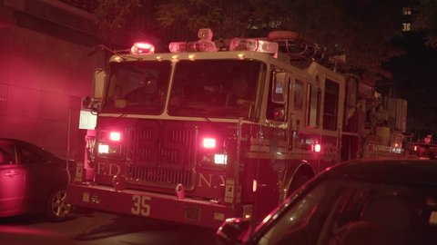 NEW YORK - MAY 15, 2016: FDNY fire trucks with flashing lights standing on street in the city at night. fire department emergency scene