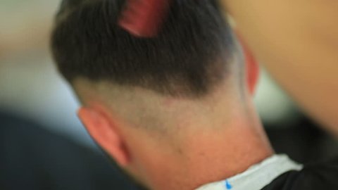 Barber cuts the hair of the client with scissors - close up detail shot