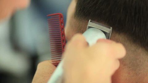 Barber cuts the hair of the client with scissors - close up detail shot