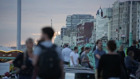 Crowds of people on a beach promenade in Brighton, England
