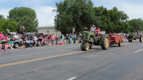 FOUNTAIN GREEN, UTAH - JUL 2016: Rural community parade antique tractors farm equipment. Fourth of July, American celebration for freedom rural town. Parade reflects community values family morals.