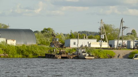 A small industrial plant on the side of the river it has metal plants and towers on it