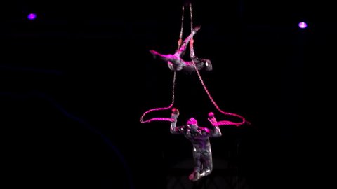 ST. PETERSBURG, RUSSIA - JANUARY 2, 2016: Brothers Zapashny circus, "UFO. Alien Planet Circus" show in Saint Petersburg. Aerial gymnasts in silver costumes perform in the air, ascending and descending