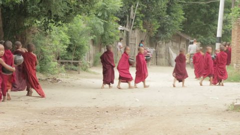 BAGAN, MYANMAR, July 4, 2016: Novice monks walking the streets collecting alms in Bagan, Myanmar (Burma)
