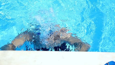 Swimmer going out of an open air pool, slow motion