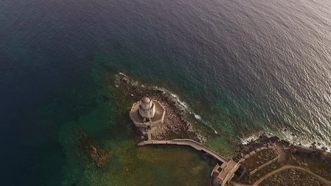 Aerial view from Methoni's Castle in Peloponnese, Greece. The fortress is located by the wonderful sea with rich coloured water. Camera orbits with the old Lighthouse centered.