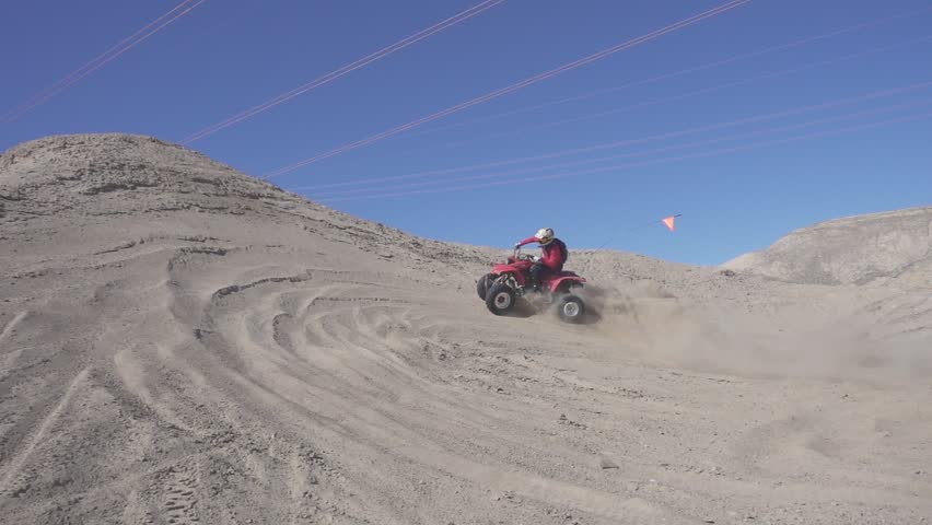 Slow motion shot of quad with big sand ejection front view