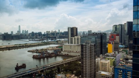 Timelapse Top View of Hong Kong Cityscape day whit clouds, skyline of the city near Kowloon Bay with ships and cars in freeway front the Harbour-Dan 