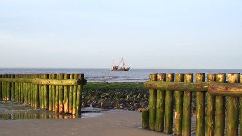 Groyne with a small fishing Cutter  in the Background at Wangerooge Island North sea Germany