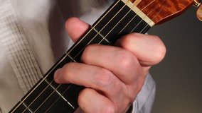 A extreme closeup view of a steel string acoustic guitar player.