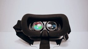 Virtual reality glasses for the smartphone on the white background, smartphone is working, mans hands take them and wear