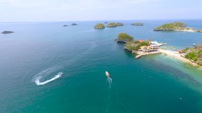 drone fly over a pump boat crossing several islands on the sea