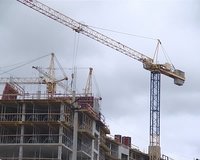 Cranes and people building the house. New apartment construction industry. 