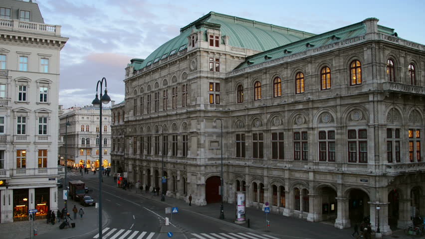 View of State Opera in Vienna, Austria during the night. Cloudy sunset sky, car traffic