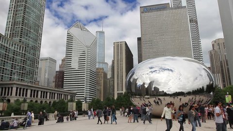 CHICAGO - CIRCA SEPTEMBER 5, 2011 - Tourists admire the Cloud Gate sculpture in Millennium Park, with skyscrapers in the background