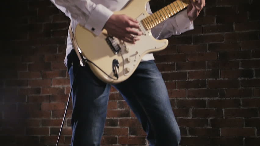 Man plays the guitar. Concert rock band performing on stage. Slow motion instrument playing