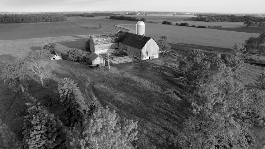 Rustic abandoned farm, scenic black and white landscape of agricultural fields, aerial view