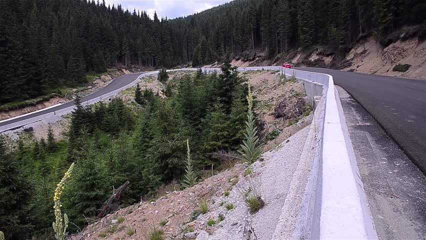 More cars down a mountain road, in coils, through a forest of trees 83
