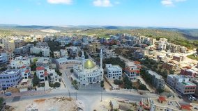 Muslim Arab village with a golden mosque on top of the mountain - Aerial footage