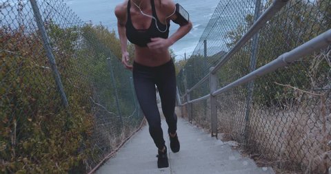Outdoor shot of fit young woman running up stairs. Female athlete climbing up the steps.
