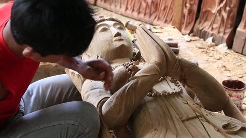 BAGAN. MYANMAR - JANUARY 22, 2016: Burmese man are making wooden souvenirs for tourists in Bagan, Myanmar. Wood Carving is a traditional handicraft in Myanmar