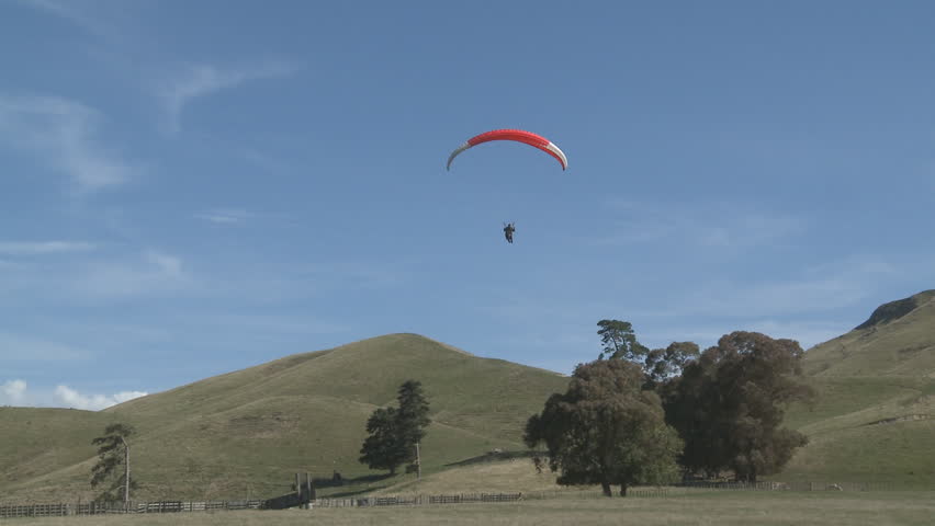 A para glider comes into land