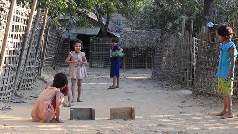 MRAUK-U, MYANMAR - JANUARY 27, 2016: Unidentified poor children playing outdoor game on the street. Poverty is a major issue in Burma